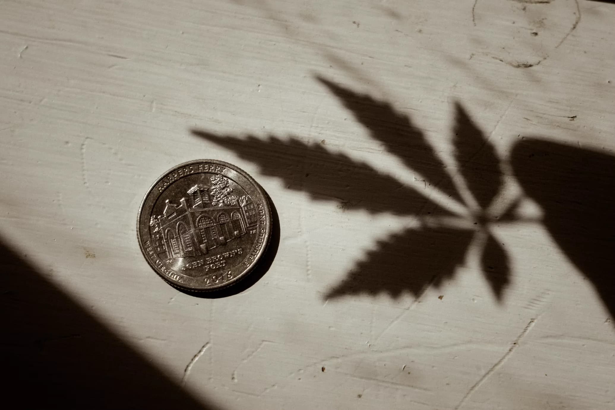 A quarter with the of a cannabis leaf shadow-sm